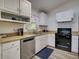 Efficient kitchen with stainless steel dishwasher and black oven with white cabinetry and practical layout at 5123 Pineland Ave, Port Orange, FL 32127