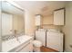 Updated bathroom with modern vanity, toilet, and a laundry area including washer and dryer at 5365 Elm Ct # 331, Orlando, FL 32811
