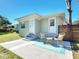 Charming backyard patio with wicker chairs, a side table, and a stylish blue outdoor rug at 611 S Montgomery Ave, Deland, FL 32720