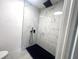 Shower featuring modern matte black fixtures and white marble tile design at 611 S Montgomery Ave, Deland, FL 32720