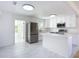 Open-concept kitchen featuring white cabinets, a kitchen island, and stainless steel appliances at 611 S Montgomery Ave, Deland, FL 32720
