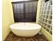 Modern bathroom featuring an oval-shaped tub and a glass block wall at 643 Cricklewood Ter, Lake Mary, FL 32746