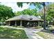 Exterior view of the community clubhouse with covered patio and seating surrounded by lush landscaping at 643 Cricklewood Ter, Lake Mary, FL 32746