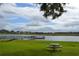 A lakeside park area with a fishing pier, picnic table and lush green grass for community enjoyment at 643 Cricklewood Ter, Lake Mary, FL 32746