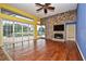 Open living room featuring a stone fireplace, hardwood floors, and sliding glass doors to the pool area at 643 Cricklewood Ter, Lake Mary, FL 32746
