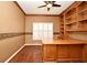 Home office with custom wood built-ins, a large desk, and a window with plantation shutters at 643 Cricklewood Ter, Lake Mary, FL 32746