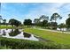 Scenic view of the community pond with lush greenery and mature trees under a bright sky at 643 Cricklewood Ter, Lake Mary, FL 32746
