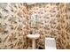 Stylish powder room showcasing unique tropical wallpaper and a pedestal sink at 643 Cricklewood Ter, Lake Mary, FL 32746