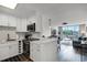 Modern kitchen open to the living area with stainless steel appliances, white cabinets, and bar seating at 1100 Delaney Ave # F407, Orlando, FL 32806