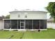 Spacious screened lanai in backyard with green lawn; solar panels on roof at 115 Willowbay Ridge St, Sanford, FL 32771