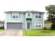Two-story home featuring a gray front door, a two-car garage, solar panels and manicured green lawn at 115 Willowbay Ridge St, Sanford, FL 32771