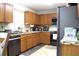 Well-lit kitchen featuring tile countertops, wood cabinets, and modern black stainless steel appliances at 115 Willowbay Ridge St, Sanford, FL 32771