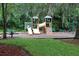 Community playground with slides, climbing structures, and ample seating surrounded by lush greenery at 115 Willowbay Ridge St, Sanford, FL 32771