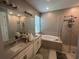 A serene primary bathroom with double vanity, soaking tub, and separate shower at 1166 Heron Sound Dr, Apopka, FL 32703