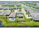 Aerial view captures a neighborhood with pond, showcasing houses with pools and well-kept lawns at 13829 Destin Beach Ln, Orlando, FL 32827