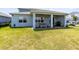 Spacious backyard with covered patio seating, manicured lawn, and secure fence for outdoor enjoyment at 13829 Destin Beach Ln, Orlando, FL 32827