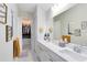 Bathroom boasts double sinks, white cabinetry, a large mirror and access to walk-in closet at 13829 Destin Beach Ln, Orlando, FL 32827