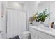 Well-lit bathroom with a shower-tub combo, single vanity, and a decorative floral arrangement at 13829 Destin Beach Ln, Orlando, FL 32827