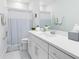 Clean, bright bathroom featuring a white vanity, a mirror, and a shower with a striped curtain at 13829 Destin Beach Ln, Orlando, FL 32827