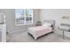Cozy bedroom features a large window and neutral decor and color tones at 13829 Destin Beach Ln, Orlando, FL 32827
