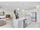 Well-lit kitchen with a large island, stainless steel appliances, white cabinets, and an open view to the living area at 13829 Destin Beach Ln, Orlando, FL 32827