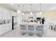 Bright kitchen with white cabinetry, stainless steel appliances, a large island with seating, and modern pendant lighting at 13829 Destin Beach Ln, Orlando, FL 32827