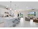 Spacious kitchen and living area featuring a large island with bar stools, modern lighting, and open floor plan at 13829 Destin Beach Ln, Orlando, FL 32827