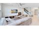 Bright living room with modern decor, a comfortable sofa, a ceiling fan, and an open view to the kitchen and stairs at 13829 Destin Beach Ln, Orlando, FL 32827