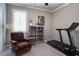 Bedroom featuring an armchair, treadmill, display cabinet, carpet flooring and natural light at 15521 Sandfield Loop, Winter Garden, FL 34787