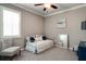 Serene bedroom with a daybed, shuttered window, soft gray walls, and elegant patterned chairs at 15521 Sandfield Loop, Winter Garden, FL 34787