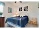 Comfortable bedroom with a white iron bed frame, blue quilt, patterned wallpaper, and hardwood accents at 15521 Sandfield Loop, Winter Garden, FL 34787