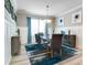Elegant dining room featuring modern chandelier, wainscoting detail, and blue accent rug at 15521 Sandfield Loop, Winter Garden, FL 34787