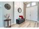Inviting entryway with white plank accent wall, decorative mirror, and a cushioned bench at 15521 Sandfield Loop, Winter Garden, FL 34787