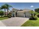 Charming home showcasing a paved driveway, a three-car garage, and beautifully maintained landscaping at 15521 Sandfield Loop, Winter Garden, FL 34787