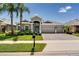 Charming single-story home featuring a three-car garage, tropical landscaping, and a paver driveway at 15521 Sandfield Loop, Winter Garden, FL 34787