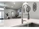 Close-up of the kitchen island featuring a faucet with a pull-down sprayer and decorative wall art at 15521 Sandfield Loop, Winter Garden, FL 34787