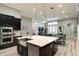 Open-concept kitchen with stainless steel appliances, an island with seating, and a view to the living area at 15521 Sandfield Loop, Winter Garden, FL 34787