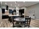 Elegant kitchen featuring sleek black cabinets, a center island, and a dining area with a round table at 15521 Sandfield Loop, Winter Garden, FL 34787