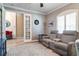 Comfortable living room with reclining gray sofa, area rug, and open doorway to the rest of the house at 15521 Sandfield Loop, Winter Garden, FL 34787