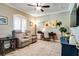 Cozy living room featuring a comfortable reclining sofa, ceiling fan, and natural light from a window at 15521 Sandfield Loop, Winter Garden, FL 34787