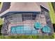 Aerial view of screened pool with two teal umbrellas and deck furniture, surrounded by green grass at 15521 Sandfield Loop, Winter Garden, FL 34787