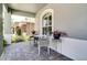Inviting front porch features a cozy seating area, brick pavers, and elegant floral accents at 15521 Sandfield Loop, Winter Garden, FL 34787