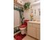 Inviting bathroom featuring a floral shower curtain, red toilet cover, and a bright vanity with a large mirror at 1603 15Th, Sanford, FL 32771