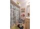 Charming bathroom featuring a shower with a floral shower curtain, toilet, and vanity with gold accents at 1603 15Th, Sanford, FL 32771