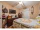 Inviting bedroom features a floral bedspread, ceiling fan, and wood-look flooring, creating a warm and inviting space at 1603 15Th, Sanford, FL 32771