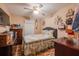 Comfortable bedroom features a floral bedspread, ceiling fan, and wood-look flooring, creating a warm and inviting space at 1603 15Th, Sanford, FL 32771