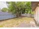 Fenced backyard with a concrete patio and lush trees, offering privacy at 1710 Espanola Ave, Daytona Beach, FL 32117