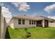 Lush green backyard with a screen lanai and view of the exterior of the home at 2043 Rock Maple Bnd, Kissimmee, FL 34746