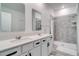 Elegant bathroom with double sinks, quartz counters, and a tiled walk-in shower at 2043 Rock Maple Bnd, Kissimmee, FL 34746