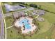 Aerial view showcases the community pool with palm trees, lounge chairs, and playground at 2043 Rock Maple Bnd, Kissimmee, FL 34746